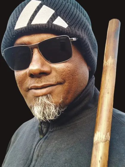 Another portrait with the Bo Staff, highlighting its natural texture and feel as a traditional training tool.