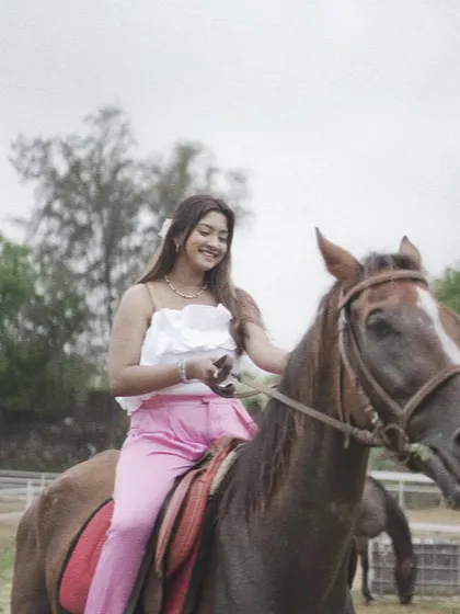 A smiling rider on horseback, demonstrating the happiness and confidence that comes from building a bond with a horse.