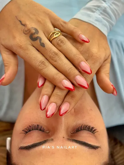 A perfect pairing of classic red French tip nails and a set of natural-looking eyelash extensions. This look is timeless, elegant, and effortlessly chic. You can see how the lashes add a soft definition to the eyes.