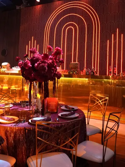 A view of the dining area at our theatre-themed Sangeet, with the glowing Art Deco bar in the background. Every corner of the venue is designed to be part of the story.
