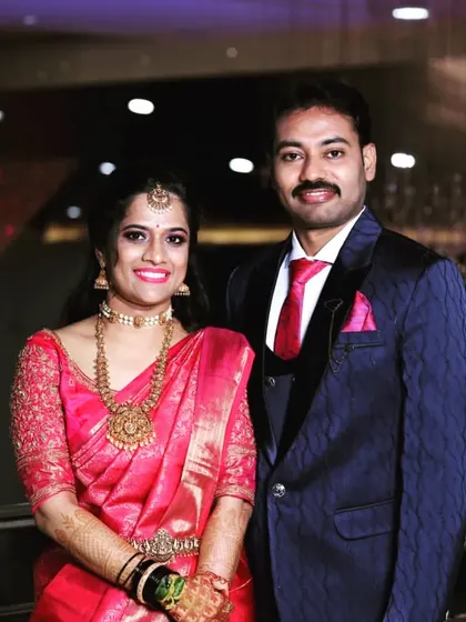 The happy couple. Nikitha's reception blouse was designed with delicate embroidery to match her pink saree.