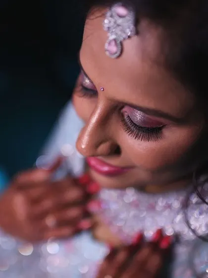 A close up shot capturing the beautiful, shimmery eye makeup and the intricate details of the bride's reception jewellery.
