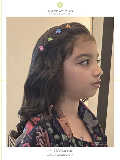 A side view of this sweet hairstyle, showing the delicate floral clips woven into the braid.