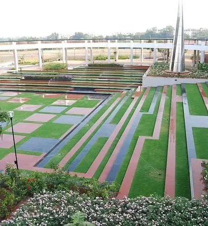 A stunning podium garden with a complex geometric design, combining grass, water features, and multi-colored pavers.