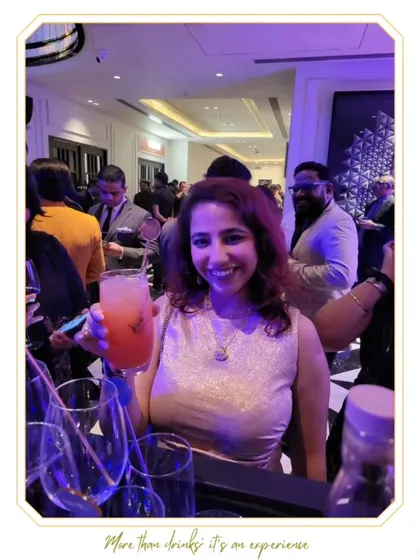 A smiling guest holds up her drink for a photo. Our goal is to create cocktails that are not only delicious but also picture-perfect.