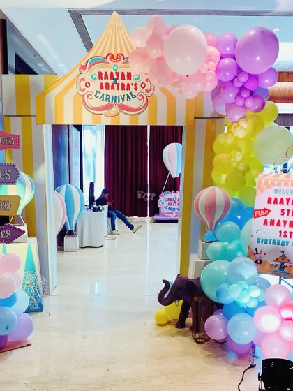 The entrance to Raayan and Anayra's Carnival, designed to look like a classic circus tent with pastel balloons.