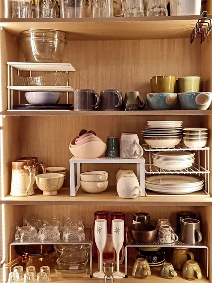 If your interior designer gave you very tall shelves, don't get frustrated. I use simple shelf risers to double the usable space and prevent risky stacking of delicate plates and bowls.