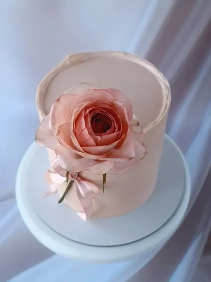 A top-down view of the wafer paper rose, showing its delicate, translucent petals.
