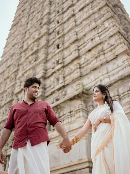 A low-angle shot that makes the couple and the temple behind them look grand and majestic. A powerful pre-wedding portrait.