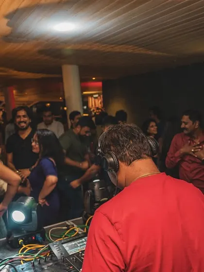 The view from behind a partygoer, looking towards me at the DJ booth.