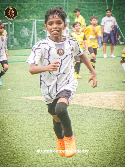 The determination to win. A young player sprints forward with the ball, showing the hustle we value.