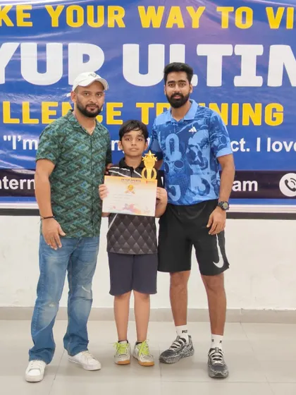 Our coaches celebrating with a student after his win at the SkyUp Open Tournament. This highlights the strong bond and mentorship that defines our coaching philosophy.
