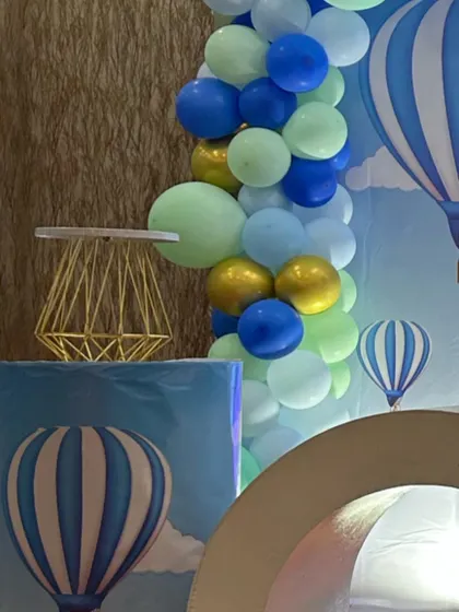 A detail from a hot air balloon themed party, showing themed props and a blue and green balloon garland.