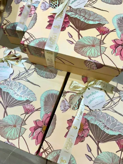 Elegant packaging for a premium Diwali gift hamper. The lotus-printed boxes are tied with a custom ribbon, ready to be filled with luxury chocolates and festive snacks for corporate clients or loved ones.