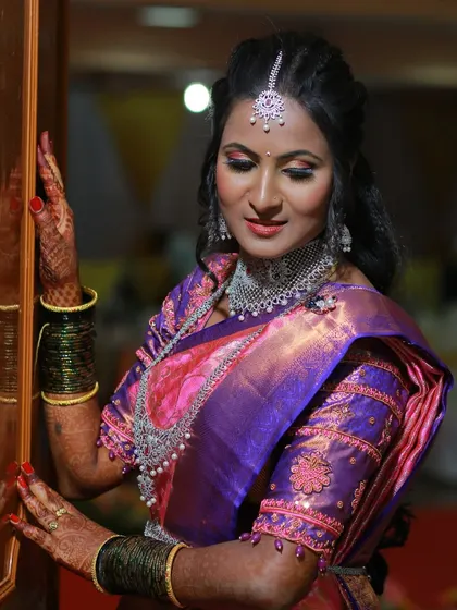 A classic bridal portrait of a South Indian bride in a beautiful purple and pink Kanjeevaram silk saree.