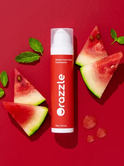 A vibrant flatlay for Orazzle's watermelon mint toothpaste. We used fresh watermelon slices and mint leaves against a bold red background to highlight the natural ingredients and flavor profile.