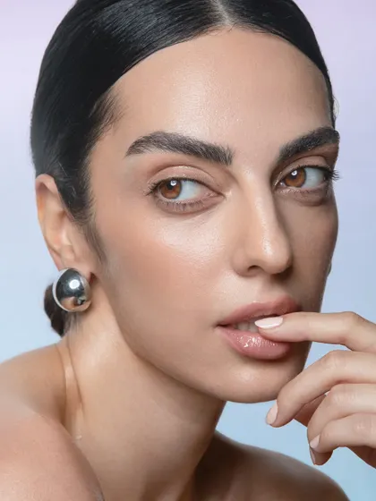 A close-up that highlights the dewy skin texture and the subtle, glossy finish on the lips.