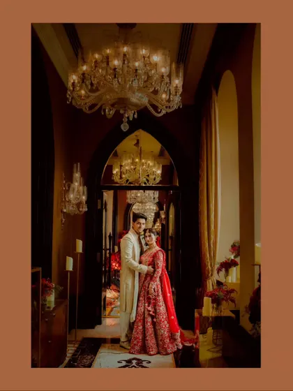 A grand and elegant portrait in a majestic hallway. The stunning chandelier and architecture add a sense of royalty to this timeless couple shot.