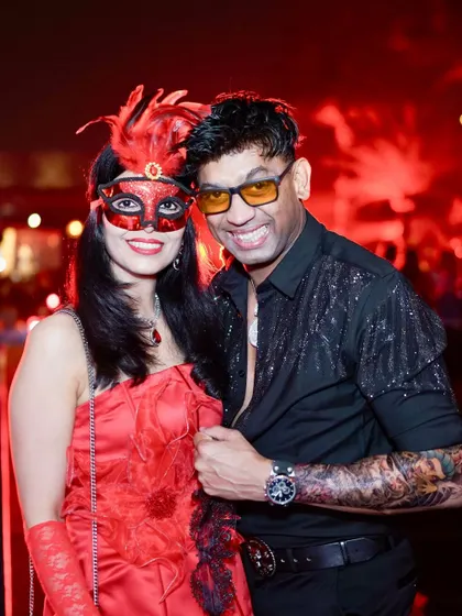 A couple in masquerade masks, adding an element of mystery and elegance to the Halloween party.