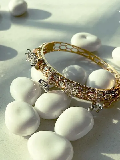 This captivating bracelet encircles your wrist with a honeycomb gold pattern and diamond charms, adding a subtle elegance to any outfit.