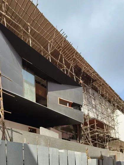 The 'House of Reddys,' a 30,000 sq ft mansion, during the construction phase. The image shows the complex scaffolding required for its ambitious, angular facade.