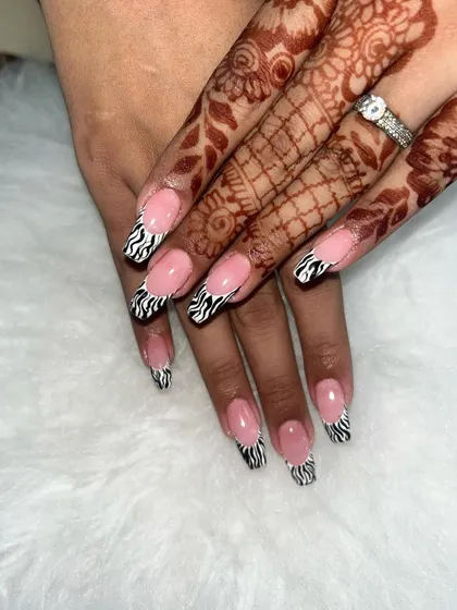 A fun take on the French manicure. These coffin-shaped nails feature a classic nude base with trendy zebra-print tips.