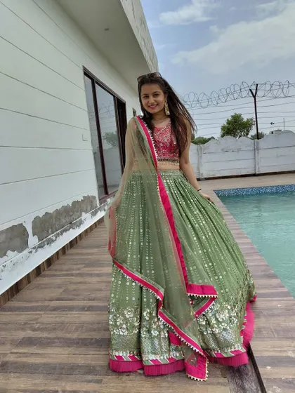 A happy twirl in the green and pink lehenga. The gota patti work on the skirt adds a touch of traditional sparkle.