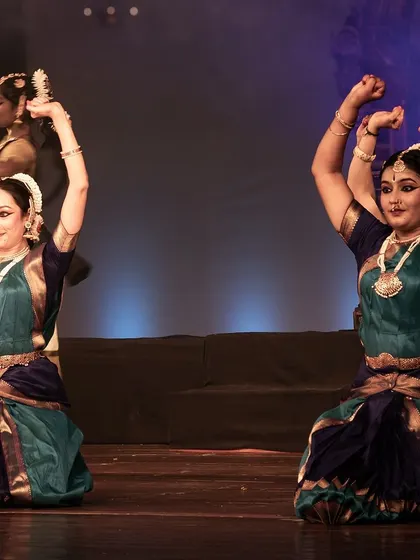 A powerful pose by two dancers, their movements perfectly mirrored.