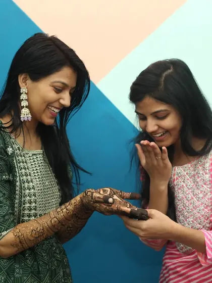 Another candid moment from the same Mehandi event, showing the genuine surprise and delight between friends. These unposed shots tell the real story of the celebration.