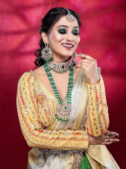 This half-saree style lehenga is a modern marvel. The heavily embroidered yellow blouse contrasts beautifully with the green skirt and light silver-grey dupatta.