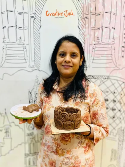 A proud student displays the intricate coiled pot she created in my pottery workshop, a perfect example of what you can make with hand-building techniques.