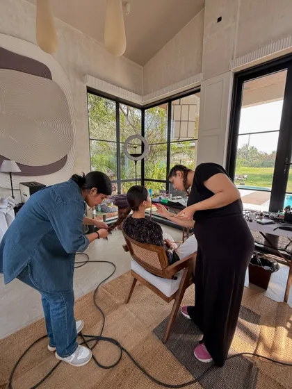 The prep work is just as important as the shoot itself. Here, the hair and makeup team gets the model ready on set, ensuring every detail is perfect before she steps in front of the camera.