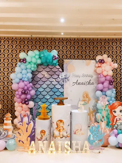 An under-the-sea adventure with a Mermaid theme. This decoration features a mermaid scale backdrop, character cutouts of Ariel, and balloon arrangements in ocean colors to create a magical underwater world.