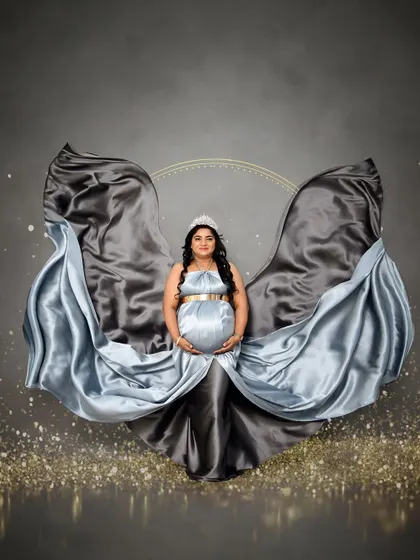 A powerful solo portrait with a flowing satin gown in shades of blue and grey. The fabric is expertly tossed to create an angelic effect against a dark, sparkling backdrop.