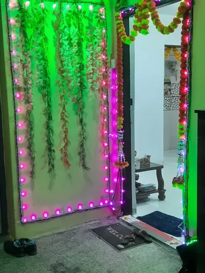 Home door decoration for a festival. I used a green foliage panel with pink and green LED lights to create this unique look.