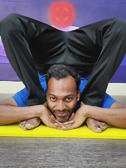 Another view of the challenging Yoganidrasana, showcasing the practitioner's calm focus and extreme flexibility.