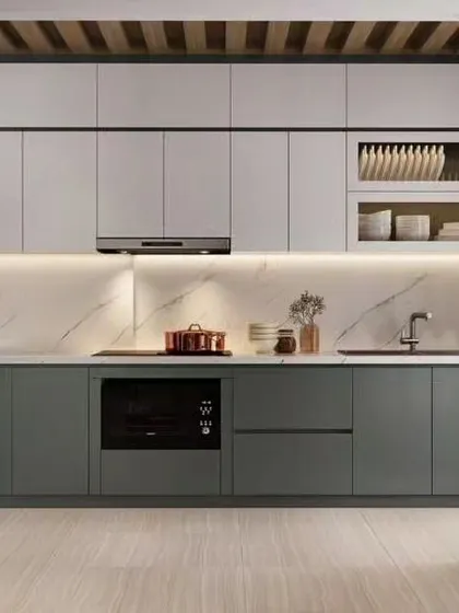 An elegant L-shaped kitchen with two-tone grey and white cabinets. The design is part of an open-plan space, defined by a stylish metal and glass room divider.