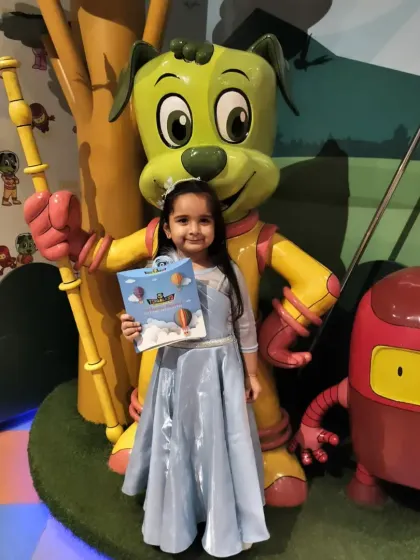 A birthday princess in her beautiful blue gown poses with our mascot statue. It's a perfect photo to remember her special day.
