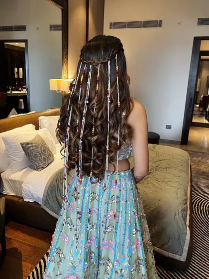 A full view of the half-up hairstyle with beaded strands, showing how it adds a playful and colorful element to the overall look.