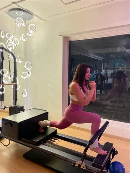 She came for the core burn and stayed for the vibe. A reformer lunge is a killer move for leg strength and stability.