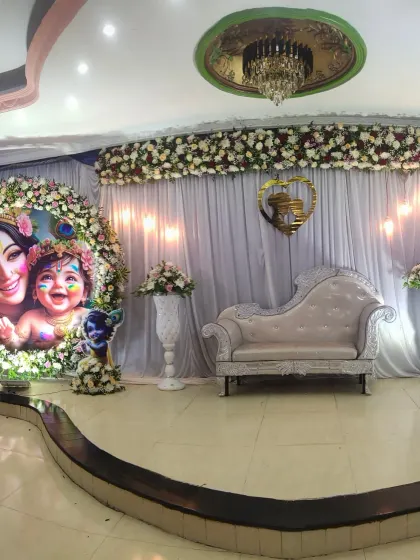 A panoramic view of the Krishna-themed baby shower stage, capturing the full backdrop and seating area.