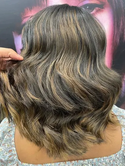 A back view of a beautifully executed balayage on a bob haircut. The placement of the lighter pieces adds depth and movement to the style.