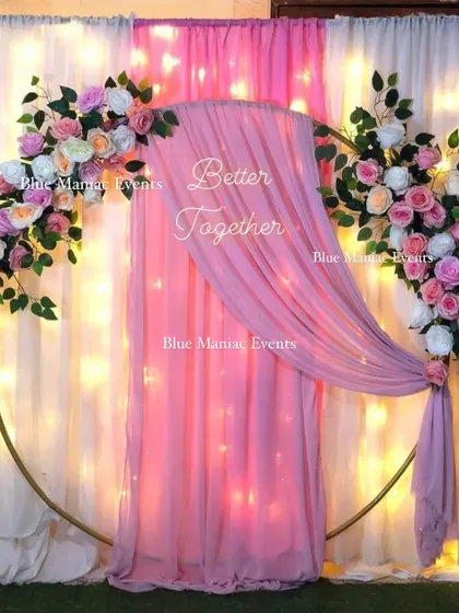 A pretty-in-pink Roka decoration. The golden ring frame is decorated with pastel pink flowers and a flowing pink drape, creating a soft and romantic photo corner.