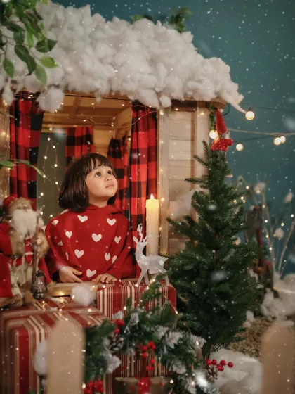Looking up at the falling snow, this little girl is lost in the magic of Christmas.