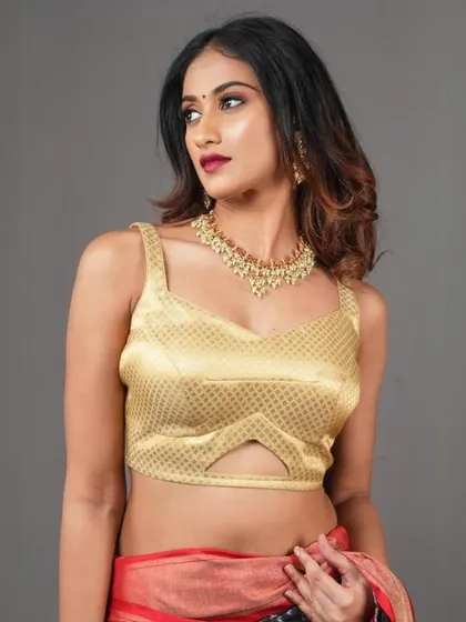 A modern gold bustier-style blouse is paired with a simple gold choker, creating a chic and glamorous look.