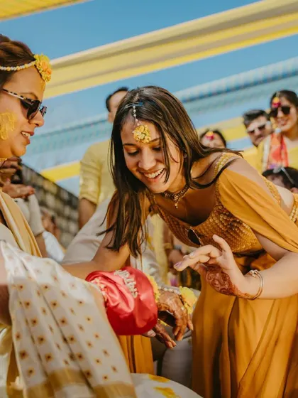 A candid shot from a Haldi ceremony. It's these moments of pure, unscripted fun and laughter that truly tell the story of your wedding.