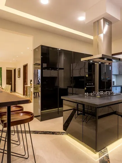 A wide view of the stunning black and white island kitchen, showing its connection to the dining area and the overall luxurious feel of the space.