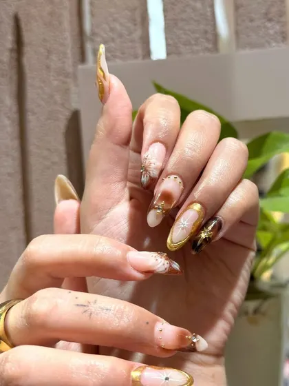 A side view highlighting the length and elegant almond shape of these custom-painted nail extensions.