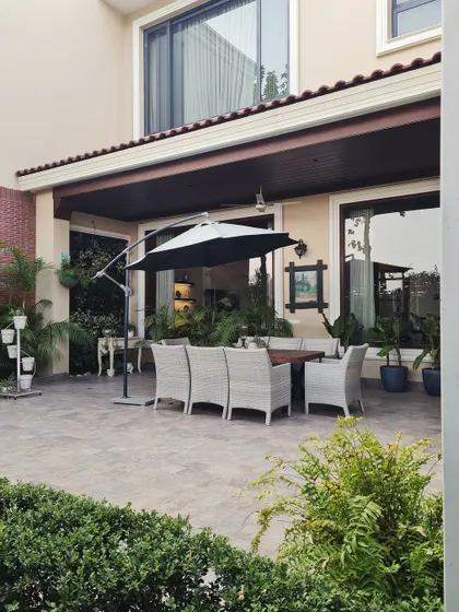 This backyard patio is the perfect blend of classic farmhouse warmth and serene outdoor living. The covered dining area provides a seamless transition from the interior to the garden.