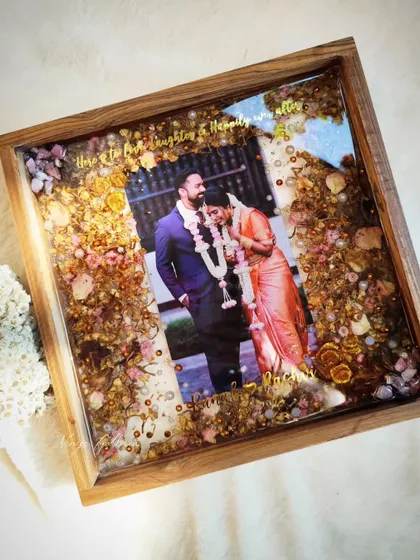 An angled view of the finished 12x12 inch wooden frame, highlighting its glossy finish and the depth of the preserved flowers.